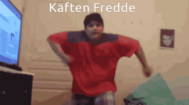 a man in a red shirt is jumping in front of a television with the words kaften fredde written on the bottom