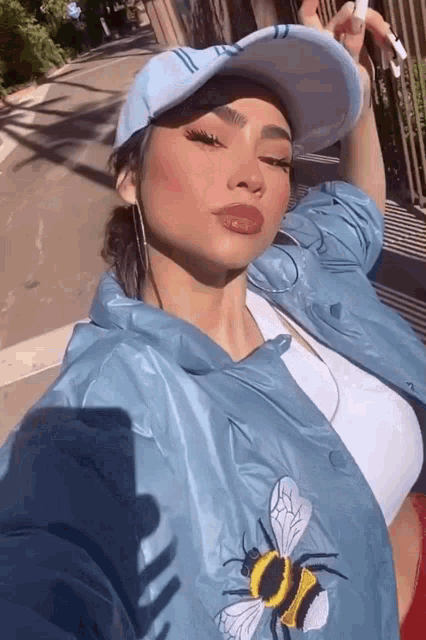 a woman wearing a blue jacket with a bee on it