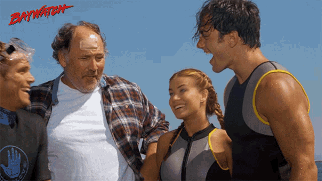 a group of people standing next to each other with the word baywatch on the bottom left