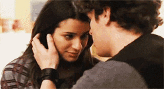 a man is touching a woman 's forehead with his hand