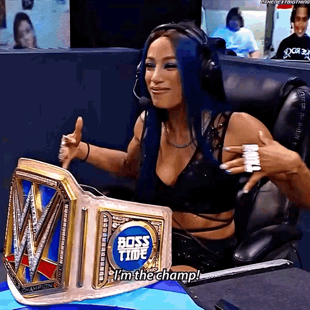 a woman is sitting in a chair with a boss time championship belt