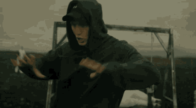 a man wearing a black hoodie with the letter a on the front