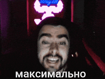 a man with a beard is wearing headphones and smiling in front of a neon sign that says stray led
