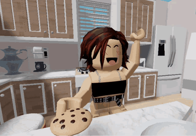 a girl in a kitchen holding a cookie with chocolate chips