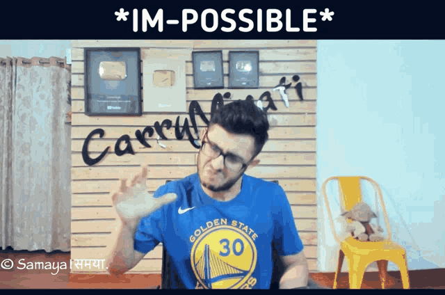 a man wearing a blue golden state warriors shirt is making a funny face