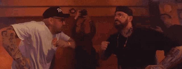 two men are standing next to each other with one wearing a hat with the letter r on it ..
