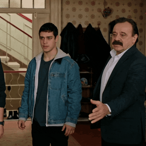 a man with a mustache is standing next to another man