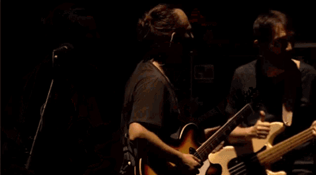 a man playing a guitar and another man playing a bass