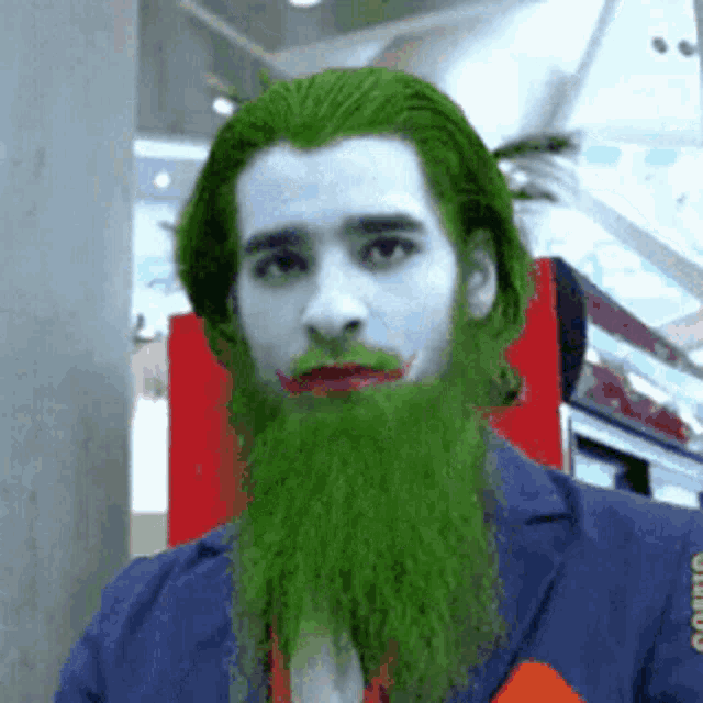 a man with a green beard and blue hair is wearing a joker costume