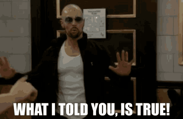 a bald man wearing sunglasses and a white tank top says what i told you is true