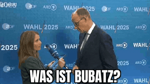 a man in a suit and tie is being interviewed by a woman with a microphone in front of a blue wall .