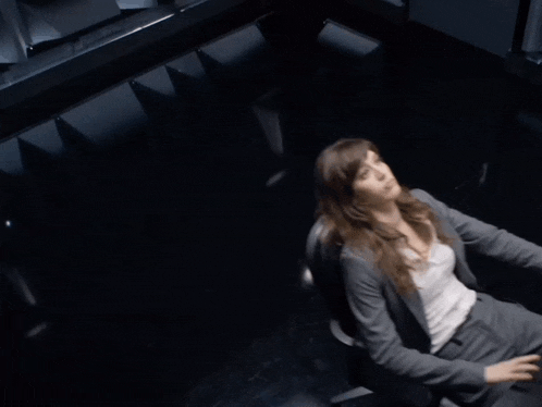 a woman in a suit sits in a chair