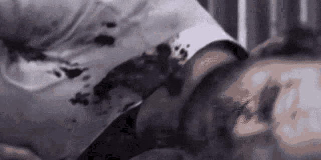 a man is laying in a hospital bed with blood coming out of his mouth .