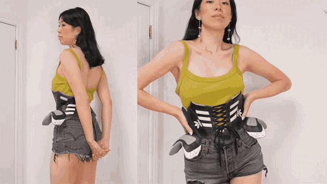 a woman wearing a green tank top and black shorts with a corset around her waist