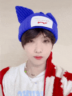 a boy wearing a blue knitted hat and a white shirt with the word avatar on it