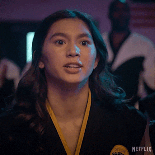 a woman is clapping her hands in front of a netflix logo .