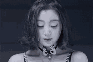 a close up of a woman 's face wearing a choker necklace .