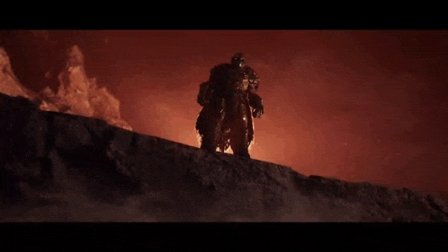 a man in armor is standing on top of a rock