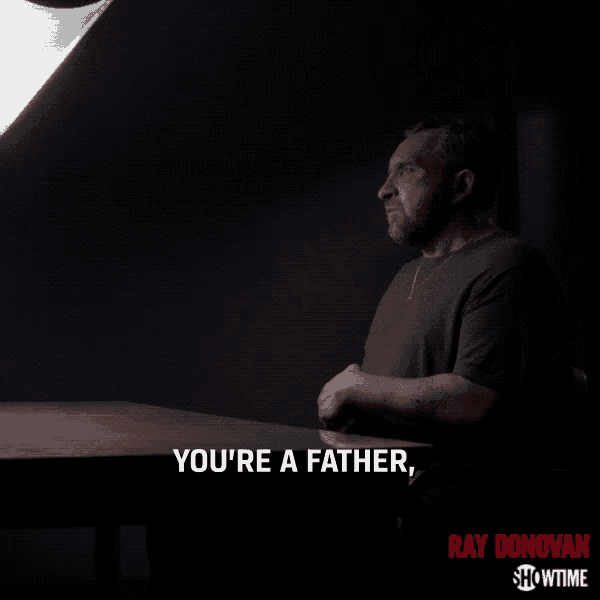 a poster for ray donovan shows a man sitting at a table in the dark