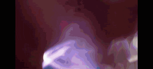 a close up of a person 's face with a purple light coming out of it