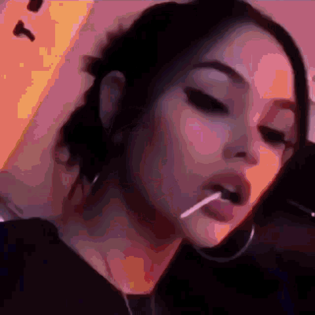a girl is eating a lollipop in her mouth .