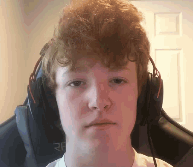 a young man with red hair is wearing headphones that say re on the back