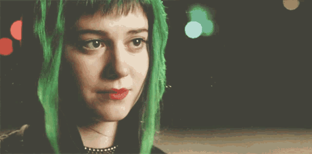 a close up of a woman with green hair