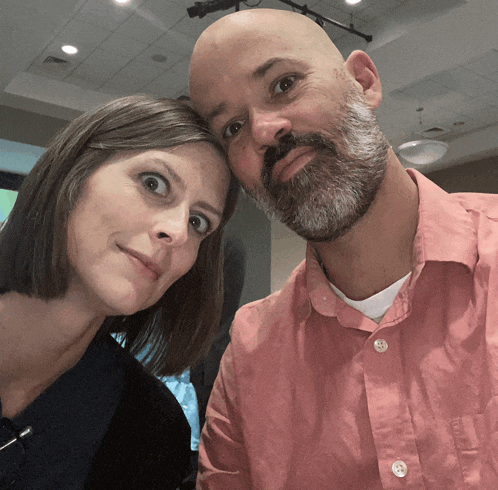 a bald man and a woman are posing for a picture together