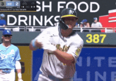 a baseball player is swinging at a ball in front of a sign that says drinks