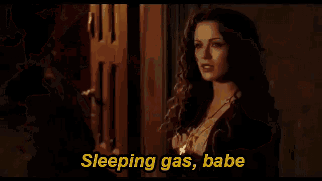 a man with long hair is holding a gun and says " sleeping gas babe "
