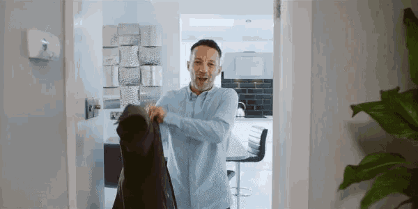 a man wearing a blue shirt is holding a black jacket