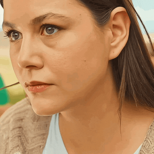 a close up of a woman 's face with a slight smile on her face