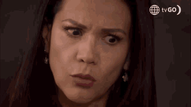a woman is making a funny face in front of a tv go sign .