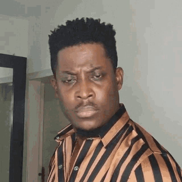 a man in a striped shirt is making a face