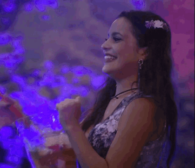 a woman in a floral dress is holding a blender in her hands