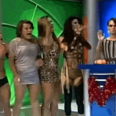 a group of people are standing in front of a green screen .