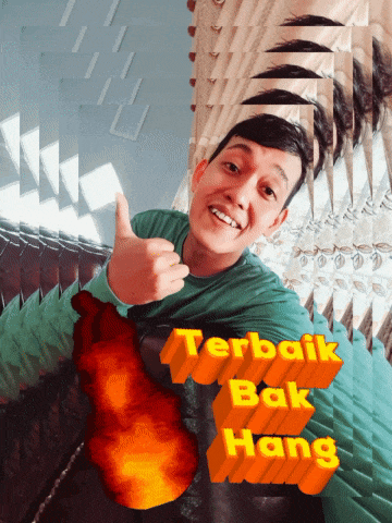 a man is giving a thumbs up with the words terbaik bak hang behind him