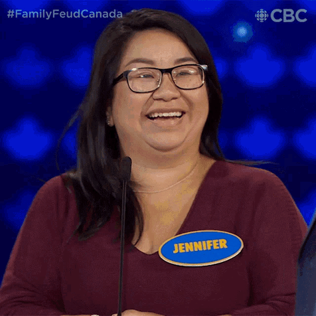 a woman with glasses and a name tag that says jennifer smiles