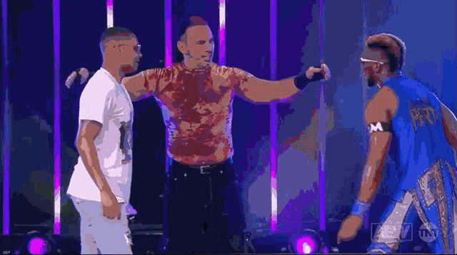 a group of men hugging each other with a tnt logo behind them