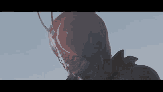 a close up of a masked superhero 's face with red eyes against a blue sky .