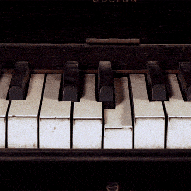 a close up of a piano keyboard with the word boston on the top left