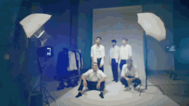 a group of men are posing for a photo in a dark room with a camera that says tz on it