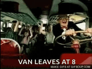 a man is driving a bus with a crowd of people on the back .