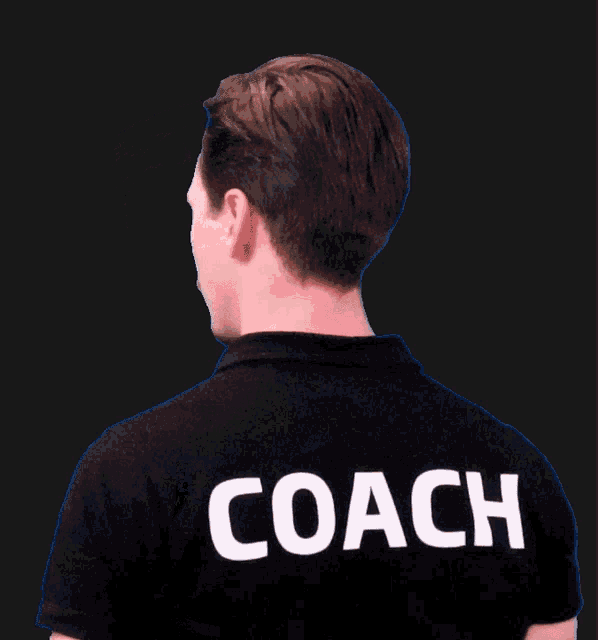 a man wearing a black shirt that says coach on it