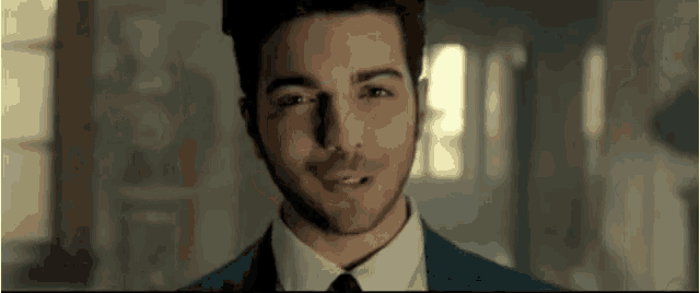 a man in a suit and tie is smiling