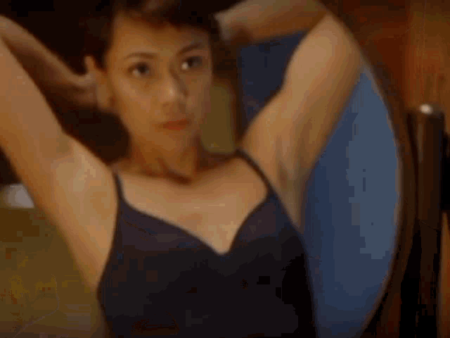 a woman in a bra is looking at herself in a mirror .
