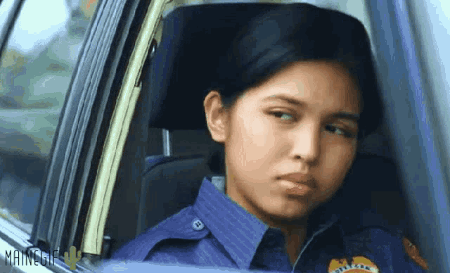 a woman in a police uniform looks out the window of a car