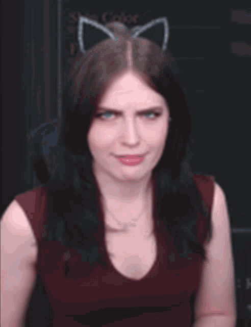 a woman wearing cat ears and a red tank top