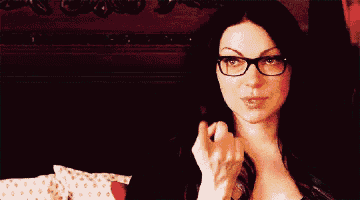 a woman wearing glasses is sitting in a chair
