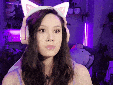 a woman wearing a cat ear headband looks surprised